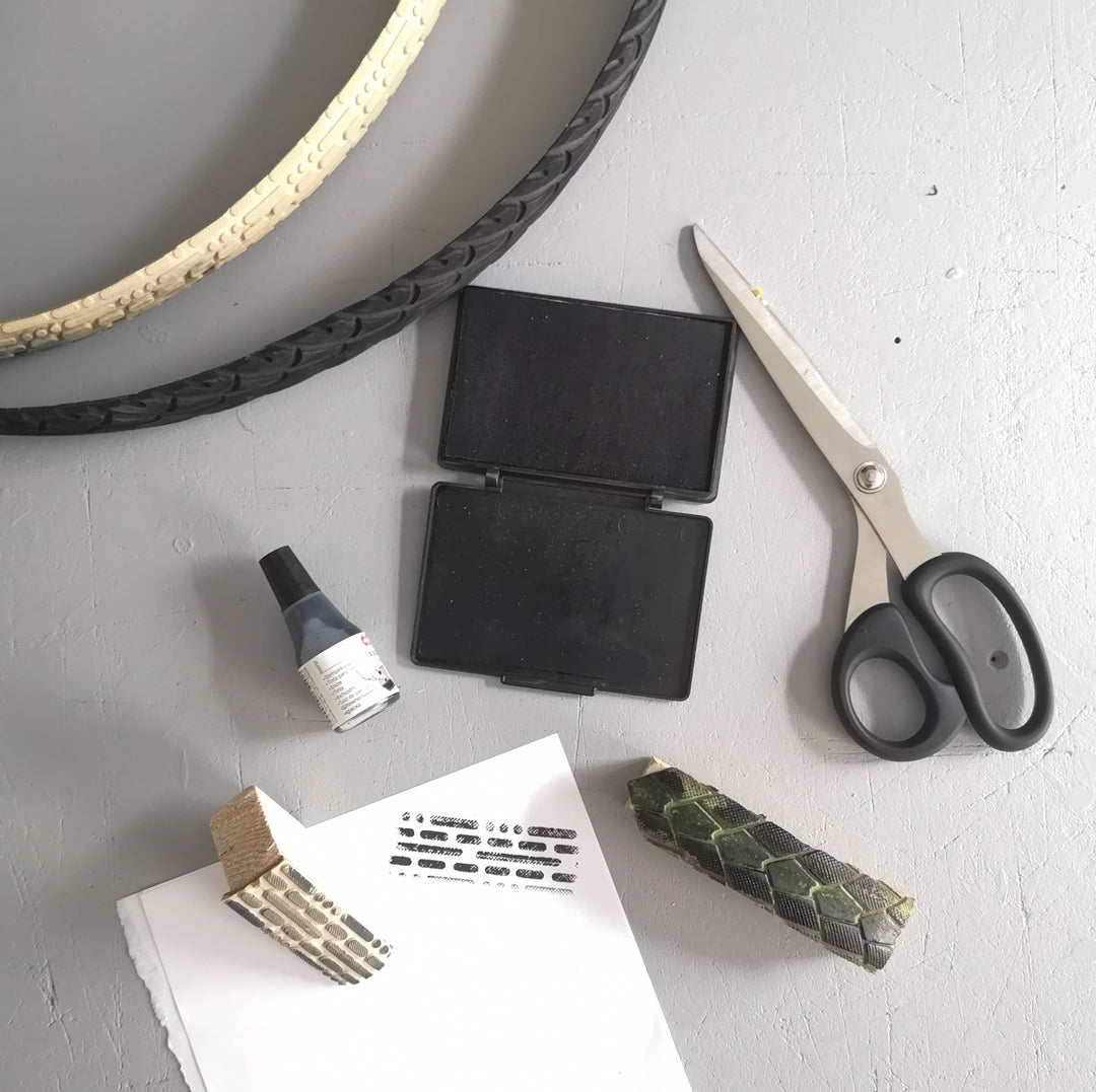 Material für selbst gemachte Stempel: Fahrradreifen, Schere, Stempelkissen und ein bedrucktes Blatt Papier.
