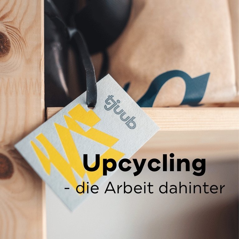 tjuub Anhänger an einer Tasche auf hellem Holz, Titelbild: Upcycling – die Arbeit dahinter.