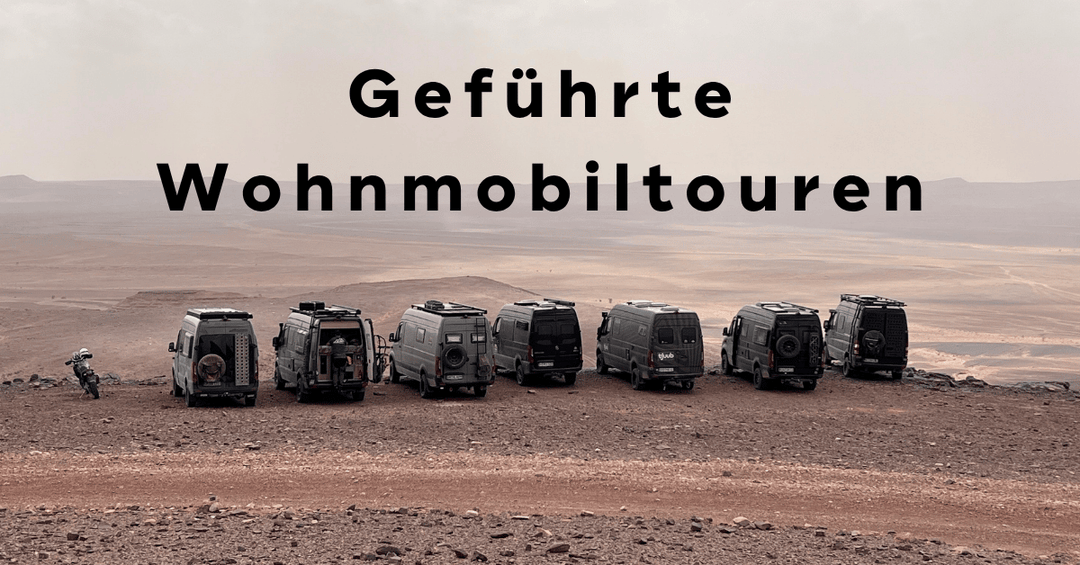 Geführte Wohnmobiltour: sieben Sprinter 4x4 Kastenwagen aufgereiht in der marokkanischen Wüste