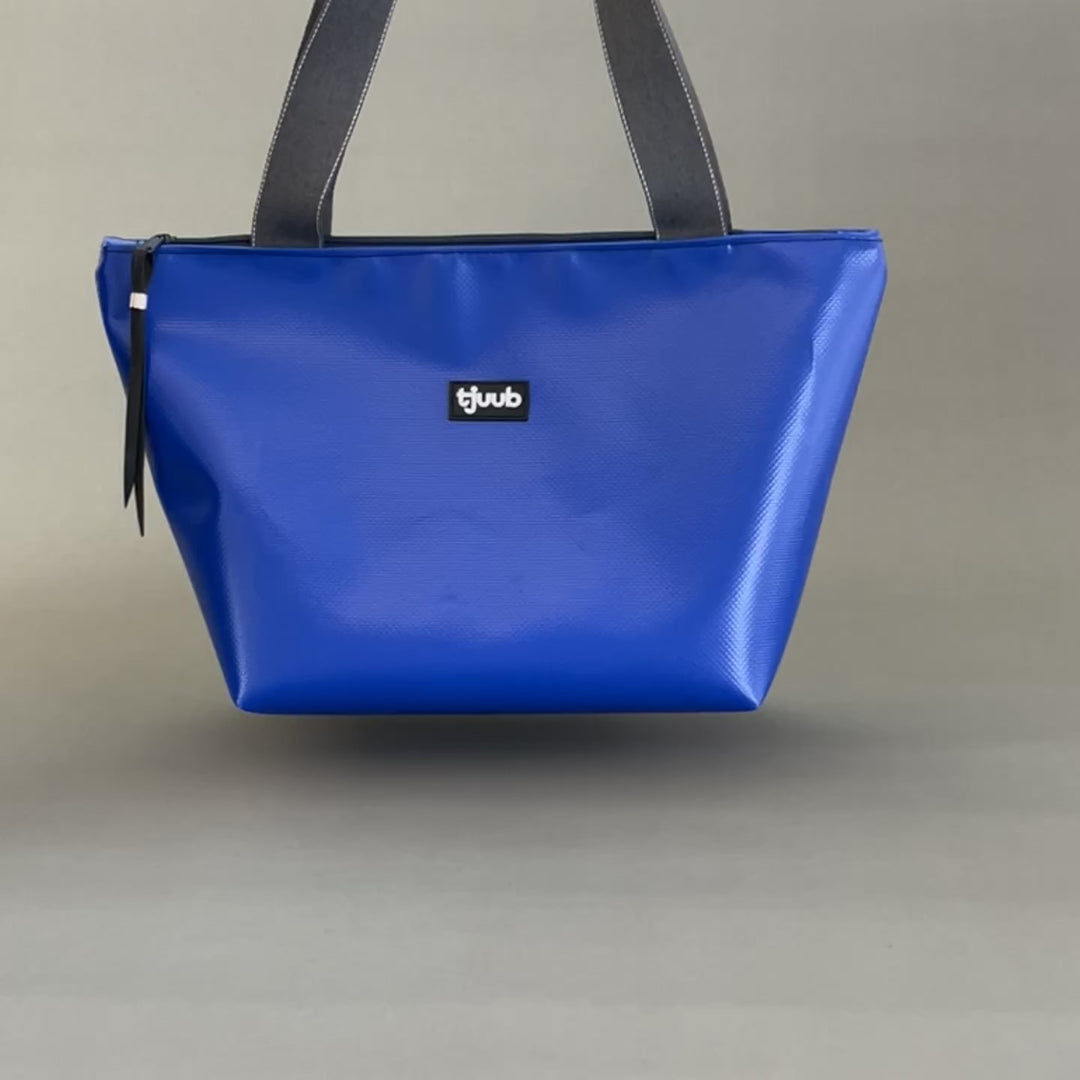 Video: Königsblaue Tasche Sila mit Reißverschluss aus LKW-Plane schwebt und wird abgestellt.