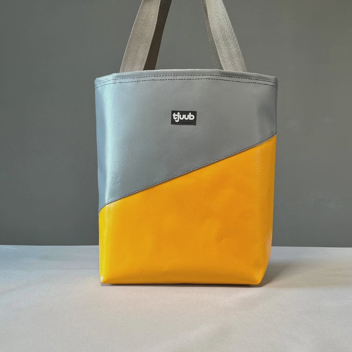 Video zeigt die handgemachte Tasche aus Plane von tjuub. Die gelb-graue EInkaufstasche aus LKW-Plane ist so vielseitig einsetzbar. Robuste Tasche als Ordnungssystem für Camper und Van, Einkaufstasche und schicker Alltagsbegleiter.