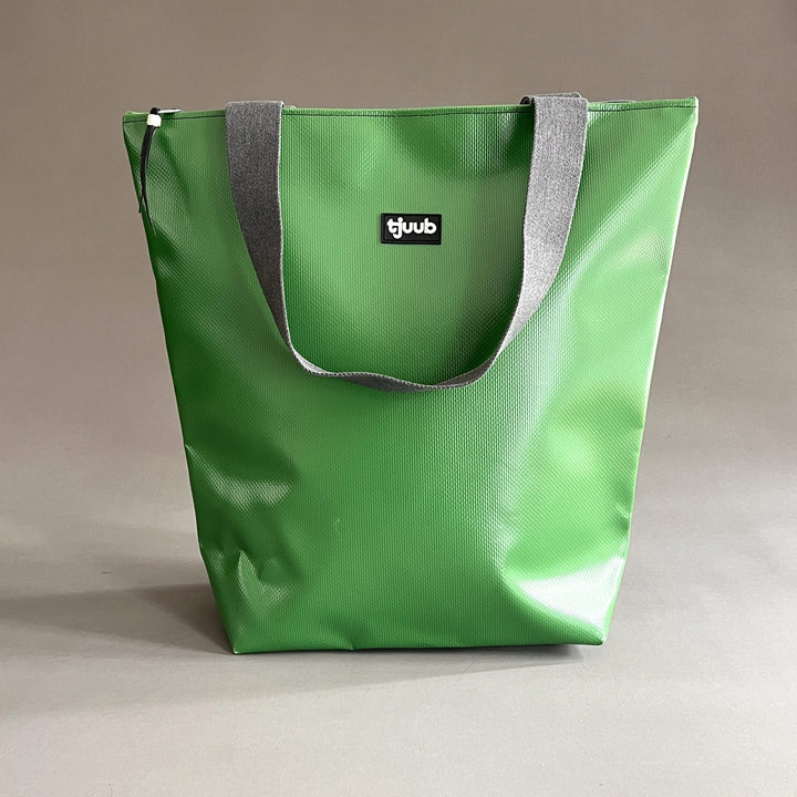 Große Tasche Lassen in Grasgrün aus recycelter LKW-Plane mit Reißverschluss und grauen Gurtbandträgern.