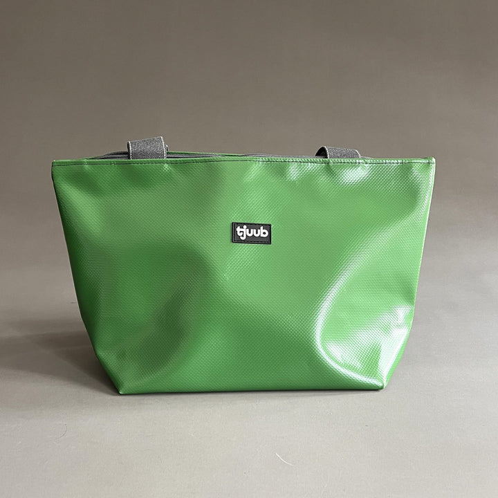 Kleine Tasche Sila in Grasgrün aus recycelter LKW-Plane ohne Reißverschluss, mit grauen Trageriemen.