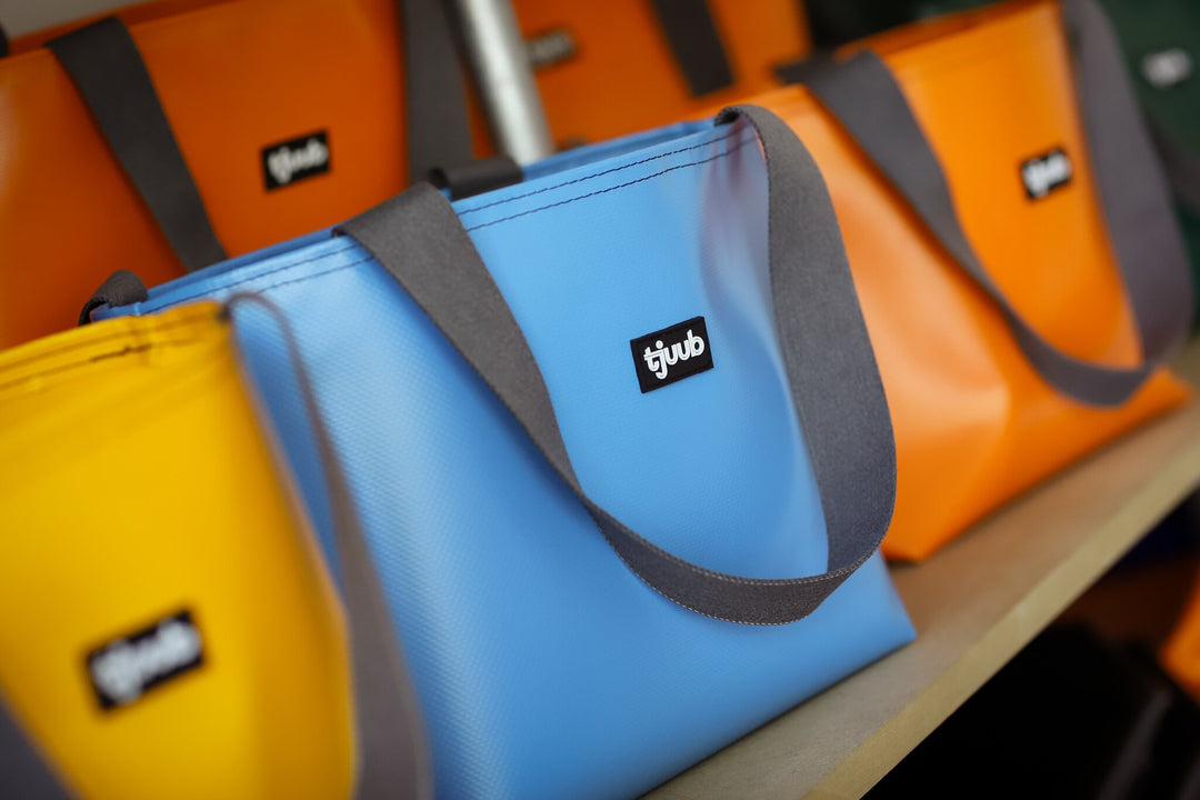 Detailaufnahme der hellblauen tjuub Tasche Sila mit grauem Gurtband und Reißverschluss.